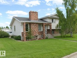Exterior featuring white horizontal siding and brick accents - 
