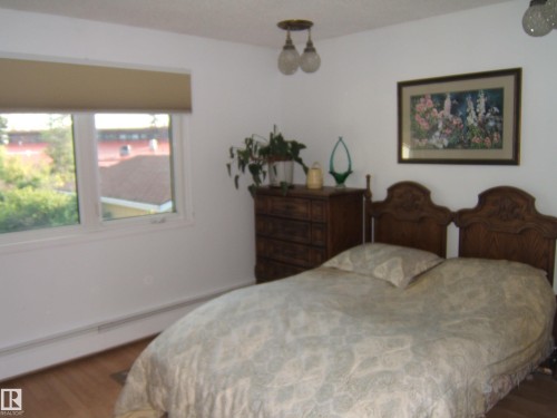 Bedroom with wood finished floors and baseboard heating - 4807 54 Avenue, Two Hills, AB - Indoor Photo Showing Bedroom
