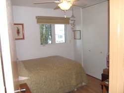 Bedroom with wood finished floors, a closet, and ceiling fan - 