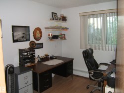 Office space with wood finished floors and a baseboard heating unit - 