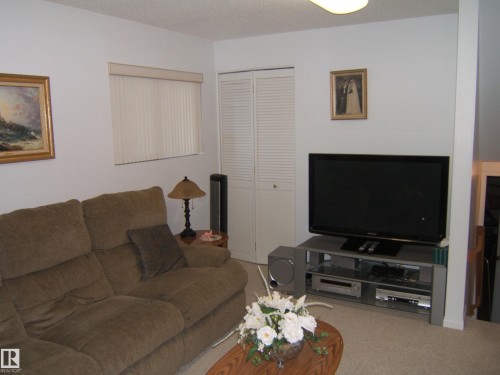Carpeted living room featuring a textured ceiling - 4807 54 Avenue, Two Hills, AB - Indoor Photo Showing Living Room