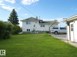Rear exterior featuring white horizontal siding and a stone-clad foundation - 