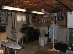 Unfinished below grade area with washer and clothes dryer and a heating unit - 