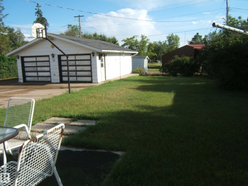 View of grassy yard with an outdoor structure and a garage - 4807 54 Avenue, Two Hills, AB - Outdoor