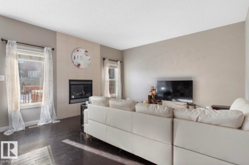Living area featuring dark wood-style floors and a fireplace - 21703 86 Avenue, Edmonton, AB - Indoor Photo Showing Living Room With Fireplace