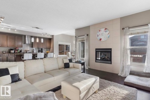 Living room with wood finished floors and a tiled fireplace - 21703 86 Avenue, Edmonton, AB - Indoor Photo Showing Living Room With Fireplace