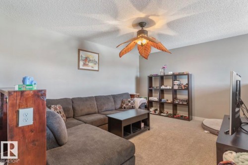 Living area featuring light carpet, a textured ceiling, and ceiling fan - 21703 86 Avenue, Edmonton, AB - Indoor Photo Showing Living Room