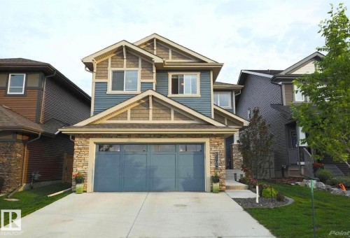 Craftsman-style home featuring stone siding, driveway, and a front yard - 21703 86 Avenue, Edmonton, AB - Outdoor