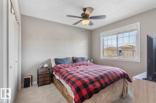 Carpeted bedroom featuring a closet, a textured ceiling, and ceiling fan - 21703 86 Avenue, Edmonton, AB - Indoor Photo Showing Bedroom