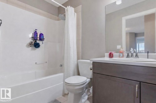 Full bath featuring vanity, shower / tub combo with curtain, and light tile patterned floors - 21703 86 Avenue, Edmonton, AB - Indoor Photo Showing Bathroom