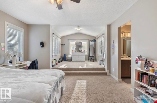Bedroom with light colored carpet, ensuite bath, and ceiling fan - 21703 86 Avenue, Edmonton, AB - Indoor Photo Showing Bedroom