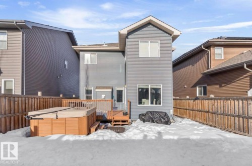 Snow covered house with a hot tub, a deck, and a fenced backyard - 21703 86 Avenue, Edmonton, AB - Outdoor With Exterior