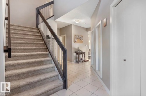 Stairway with baseboards and tile patterned floors - 21703 86 Avenue, Edmonton, AB - Indoor Photo Showing Other Room