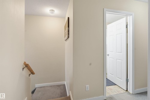 Stairway featuring carpet and a textured ceiling - 8 230 Edwards Drive, Edmonton, AB - Indoor Photo Showing Other Room