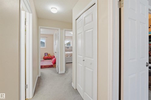 Hallway with light carpet and baseboards - 8 230 Edwards Drive, Edmonton, AB - Indoor Photo Showing Other Room