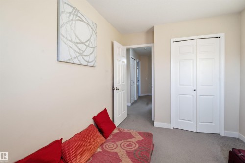 Unfurnished bedroom featuring light carpet and a closet - 8 230 Edwards Drive, Edmonton, AB - Indoor Photo Showing Other Room