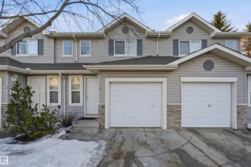Traditional-style house with concrete driveway, stone siding, and roof with shingles - 8 230 Edwards Drive, Edmonton, AB - Outdoor With Facade