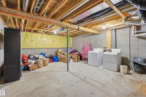 Unfinished basement featuring washer and clothes dryer - 8 230 Edwards Drive, Edmonton, AB - Indoor