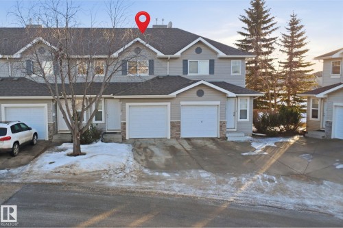 Traditional-style home with driveway, stone siding, a garage, and a shingled roof - 8 230 Edwards Drive, Edmonton, AB - Outdoor With Facade