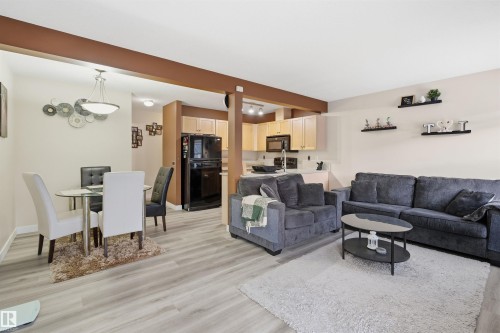 Living area with light wood-style flooring and baseboards - 8 230 Edwards Drive, Edmonton, AB - Indoor Photo Showing Living Room