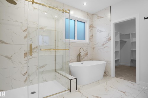 Bathroom with a marble finish shower, marble tiled flooring, a soaking tub, tile walls, and a walk in closet - 6228 29 Avenue, Edmonton, AB - Indoor Photo Showing Bathroom
