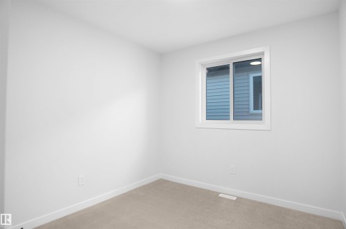 Spare room featuring baseboards and light colored carpet - 6228 29 Avenue, Edmonton, AB - Indoor Photo Showing Other Room