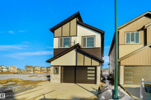 View of front facade featuring a residential view, a garage, brick siding, and driveway - 6228 29 Avenue, Edmonton, AB - Outdoor