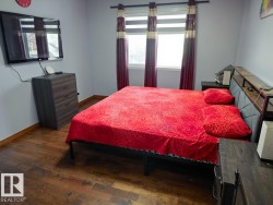 Bedroom with dark wood-style floors and baseboards - 