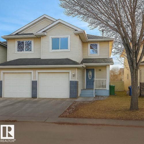 View of front of property featuring an attached garage and concrete driveway - 4 4350 23 Street, Edmonton, AB - Outdoor With Facade