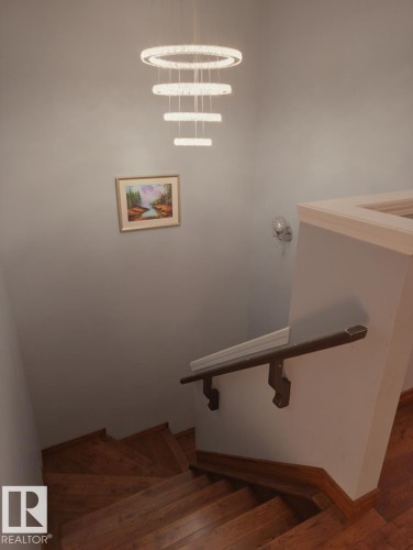 Stairway featuring hardwood / wood-style flooring and baseboards - 4 4350 23 Street, Edmonton, AB - Indoor Photo Showing Other Room