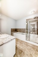 Full bathroom featuring vanity, a garden tub, and a shower stall - 