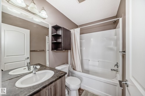 Full bath featuring shower / bath combo with shower curtain, vanity, and a textured ceiling - 9332 211 Street Nw, Edmonton, AB - Indoor Photo Showing Bathroom