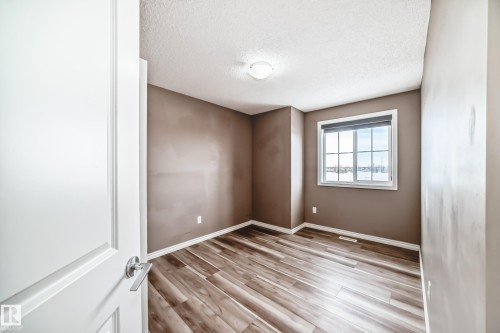 Unfurnished room with a textured ceiling and light wood finished floors - 9332 211 Street Nw, Edmonton, AB - Indoor Photo Showing Other Room