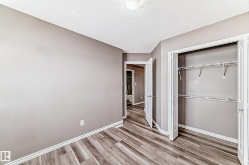 Unfurnished bedroom with a closet, light wood finished floors, and a textured ceiling - 9332 211 Street Nw, Edmonton, AB - Indoor Photo Showing Other Room