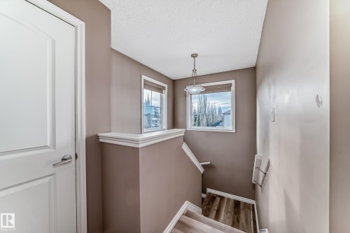 Stairway featuring a textured ceiling and wood finished floors - 9332 211 Street Nw, Edmonton, AB - Indoor Photo Showing Other Room