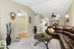 Carpeted living room featuring baseboards and ceiling fan - 