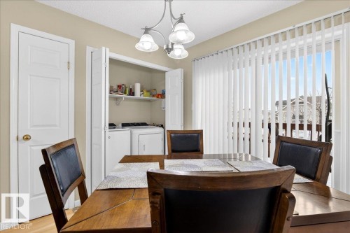 Dining space with a chandelier, independent washer and dryer, and wood finished floors - 13217 155 Avenue Nw, Edmonton, AB - Indoor Photo Showing Dining Room