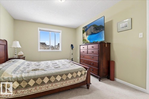 Carpeted bedroom with a textured ceiling and baseboards - 13217 155 Avenue Nw, Edmonton, AB - Indoor Photo Showing Bedroom