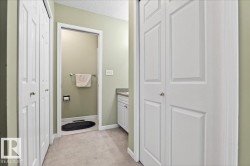 Bathroom with a closet, vanity, light colored carpet, and a textured ceiling - 