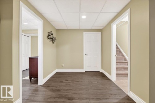 Empty room featuring dark wood-style floors, a paneled ceiling, and recessed lighting - 13217 155 Avenue Nw, Edmonton, AB - Indoor Photo Showing Other Room