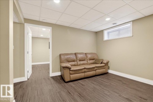 Living area featuring wood finished floors, a paneled ceiling, and recessed lighting - 13217 155 Avenue Nw, Edmonton, AB - Indoor Photo Showing Basement