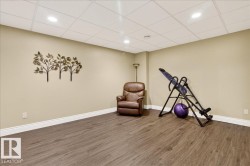 Exercise area featuring wood finished floors, a drop ceiling, and recessed lighting - 