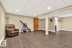 Workout room featuring wood finished floors, a paneled ceiling, and recessed lighting - 