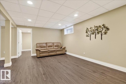 Living area featuring dark wood finished floors, a drop ceiling, and recessed lighting - 13217 155 Avenue Nw, Edmonton, AB - Indoor