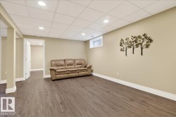 Living area featuring dark wood finished floors, a drop ceiling, and recessed lighting - 