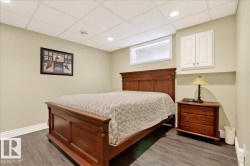 Bedroom featuring a drop ceiling, wood finished floors, and recessed lighting - 
