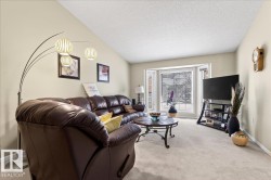 Living room with light carpet and baseboards - 