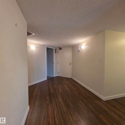 Spare room with dark wood-style floors and a textured ceiling - 2C 10050 118 Street, Edmonton, AB - Indoor Photo Showing Other Room