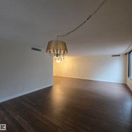 Unfurnished room with a textured ceiling, a chandelier, and dark wood-style floors - 