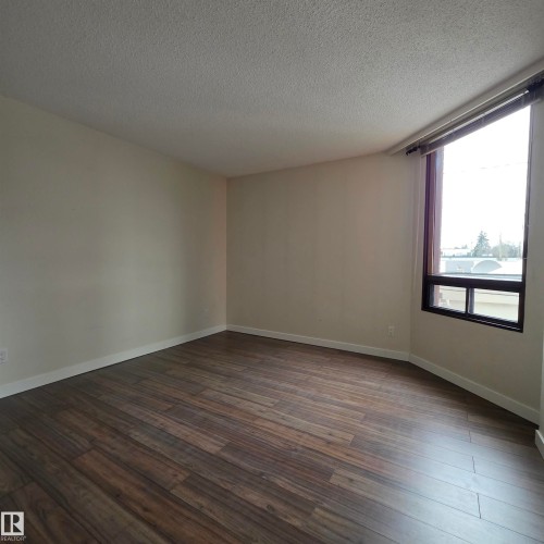 Spare room featuring dark wood finished floors and a textured ceiling - 2C 10050 118 Street, Edmonton, AB - Indoor Photo Showing Other Room
